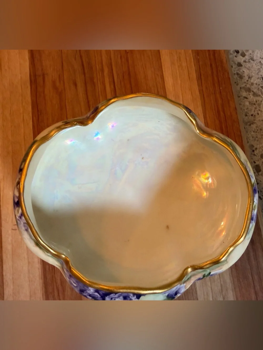A hand-painted porcelain footed bowl with gilded rim and floral decoration.